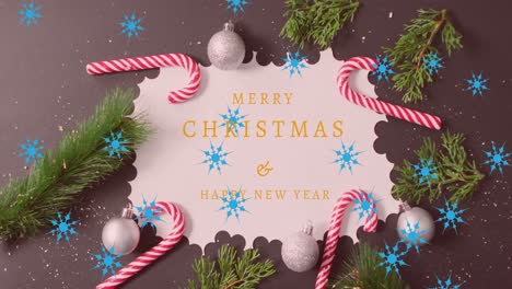 Animation-of-merry-christmas-and-happy-new-year-on-paper-with-decorations-over-brown-background