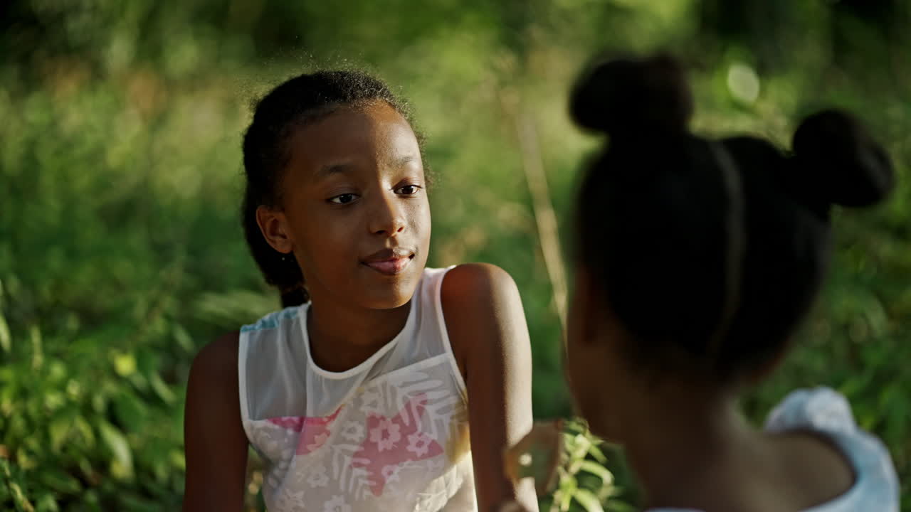 Two young girls talking outdoors