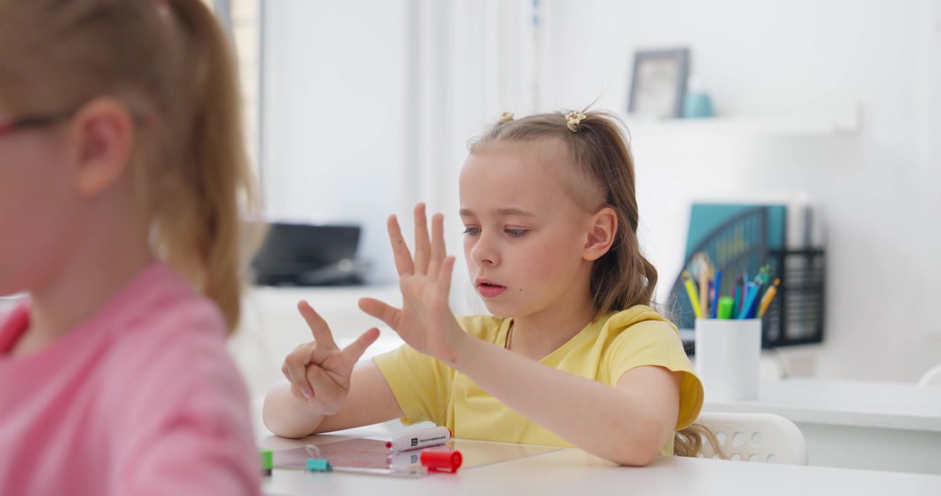 Bambina che conta sulle dita durante una lezione di matematica