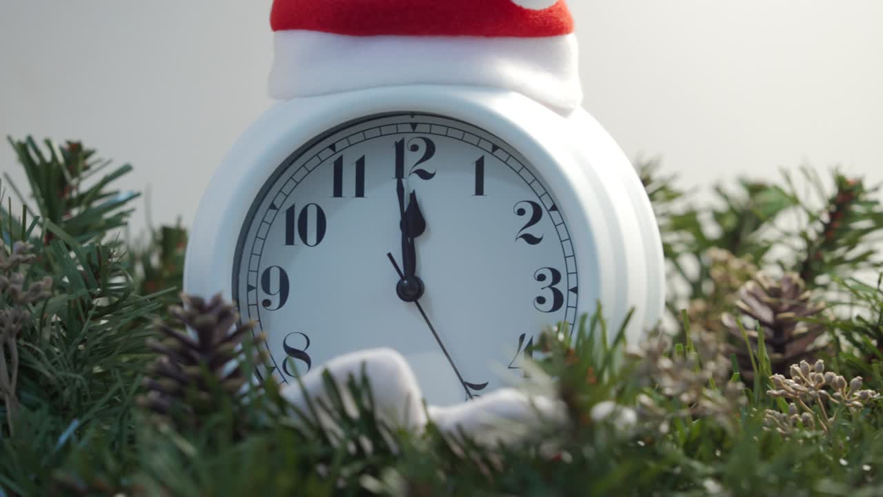 새해를 위해 자정까지 카운트 다운하는 알람 시계: 크리스마스 선물, 빛나는 은 색 선물 상자 장식 조명 사이의 금속 크리스마스 트리