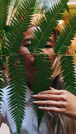 woman hiding behind ferns