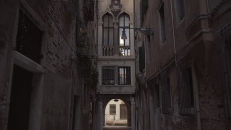 Tilt-down-shot-of-narrow-historic-street-in-Venice,-Italy
