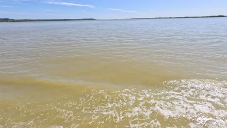 boat creates splashes on calm blaye waters