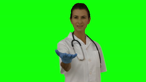 una doctora sonriente presentando con su mano