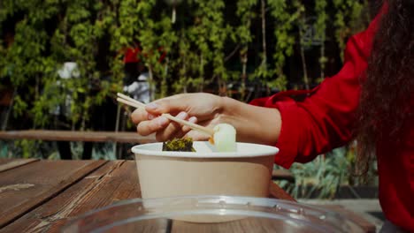 mujer comiendo sushi afuera
