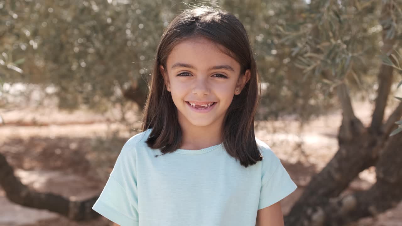 Toothless girl smiling at camera outdoors