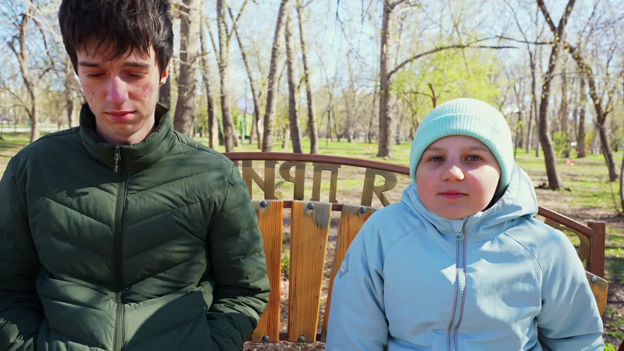 Güneşli Bir Günde Park Bankında Oturan Genç Erkek ve Kız Çocuğu