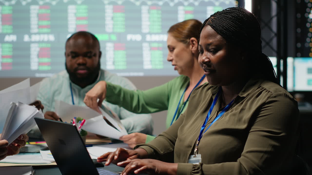 African american analyst and colleagues examining annual data reporting