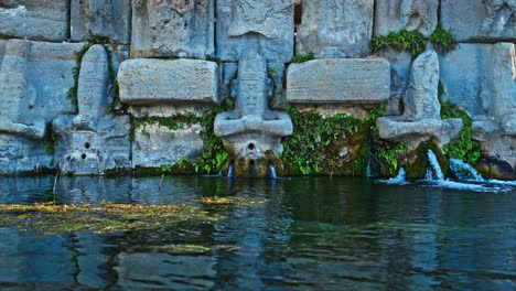the ancient stone carvings of the holy water temple, where water flows gently from the statues. 8k . 3