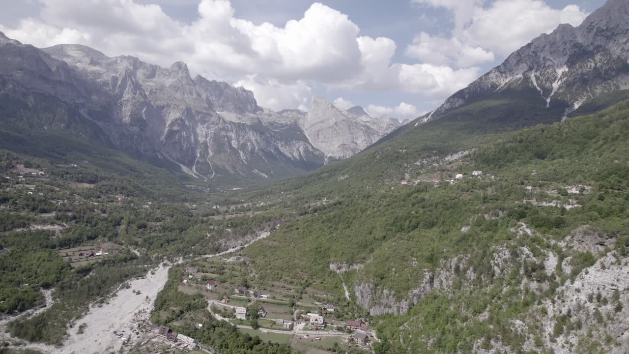 video de drone frontal avanzando dentro del valle de theth en albania, sobre el río lumi i thethit sin apenas agua, con el monte korab al fondo
