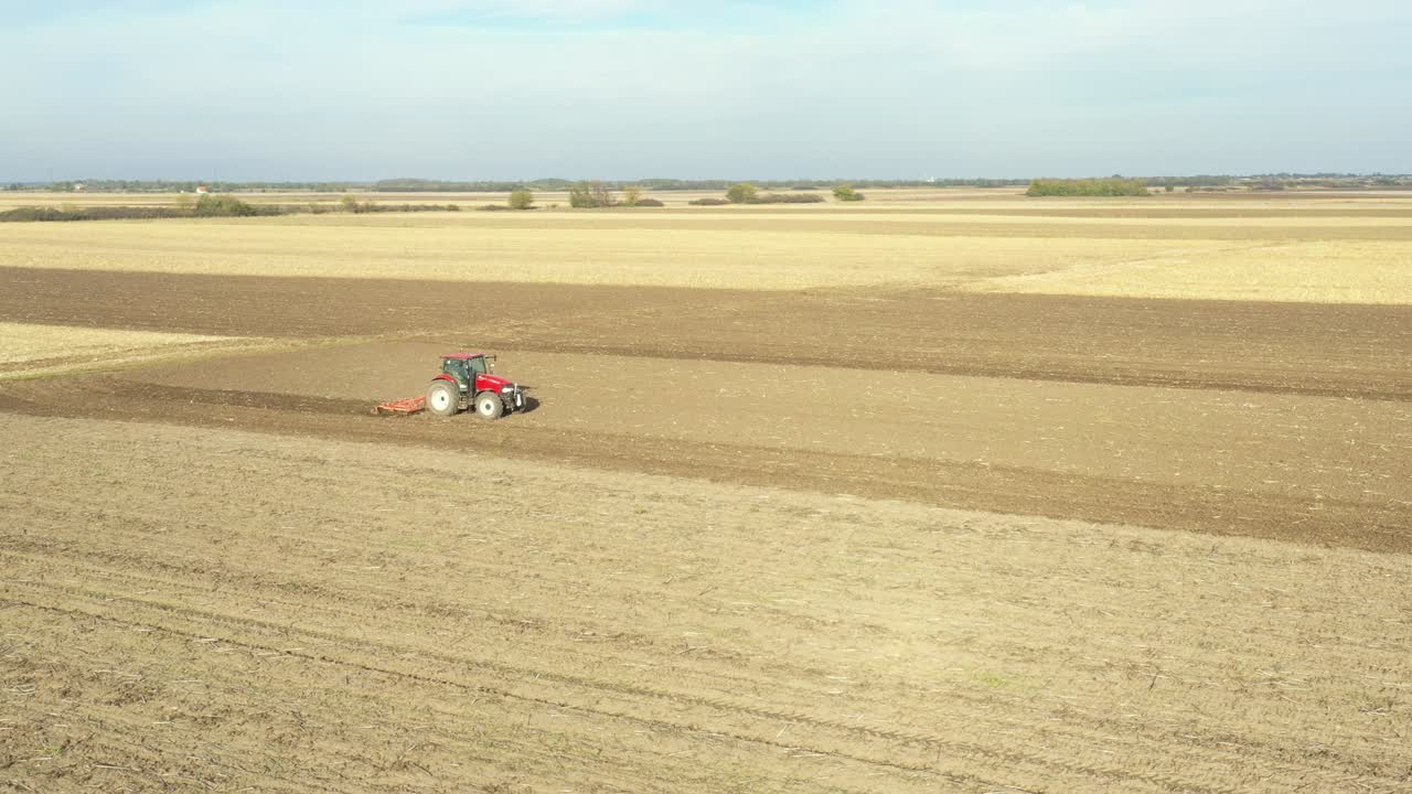 농경지, 농지 위에 씨 재배자를 끌고 다니는 트랙터의 공중 측면 이동 시각