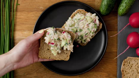 Slather-rye-bread-sandwich-with-flavorful-vegan-spread-and-garnish-with-slices-of-radish-and-chives