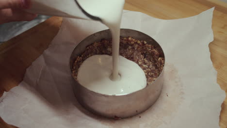 woman pours out vegetarian mix into a circular baking pan