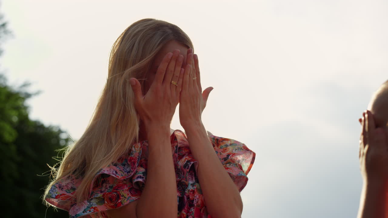 즐거운 여자와 소녀가 야외에서 장난을 치고 사랑스러운 가족이 공원에서 즐기고 있습니다.