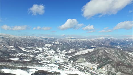 birds eye view over a snow capped mountain range under a blue sky