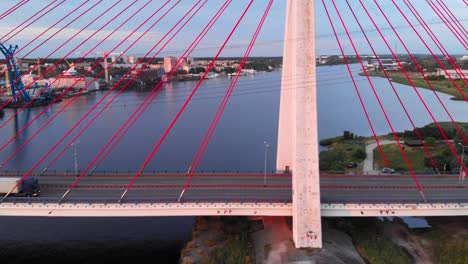 aerial shot of trucks riding aerial cable-stayed bridge on motława river in gdansk, poland