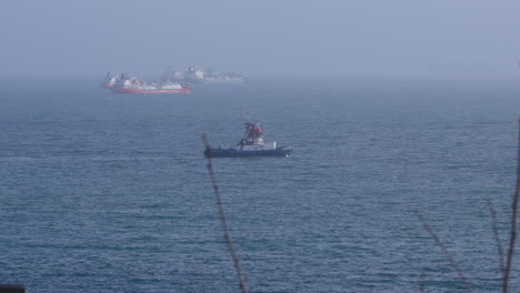 cargo ships and ship's boat near the shore
