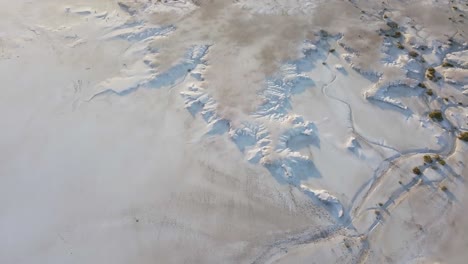 vista aérea en movimiento de un campo de sal, campo nevado con poca vegetación