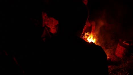 people sitting by campfire 4k
