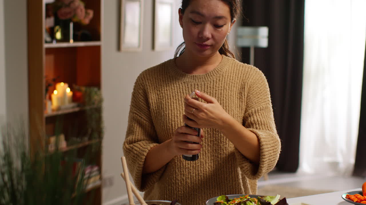 가정에서 부에서 건강한 채식주의자 또는 채식주의자의 식사를 준비하는 여성이 러드 잎의 그에 드레싱을 부어 1