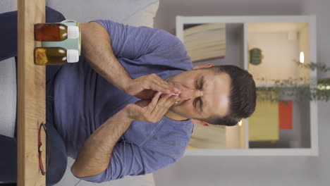 Vertical-video-of-Man-covering-mouth-and-nose-while-sneezing.
