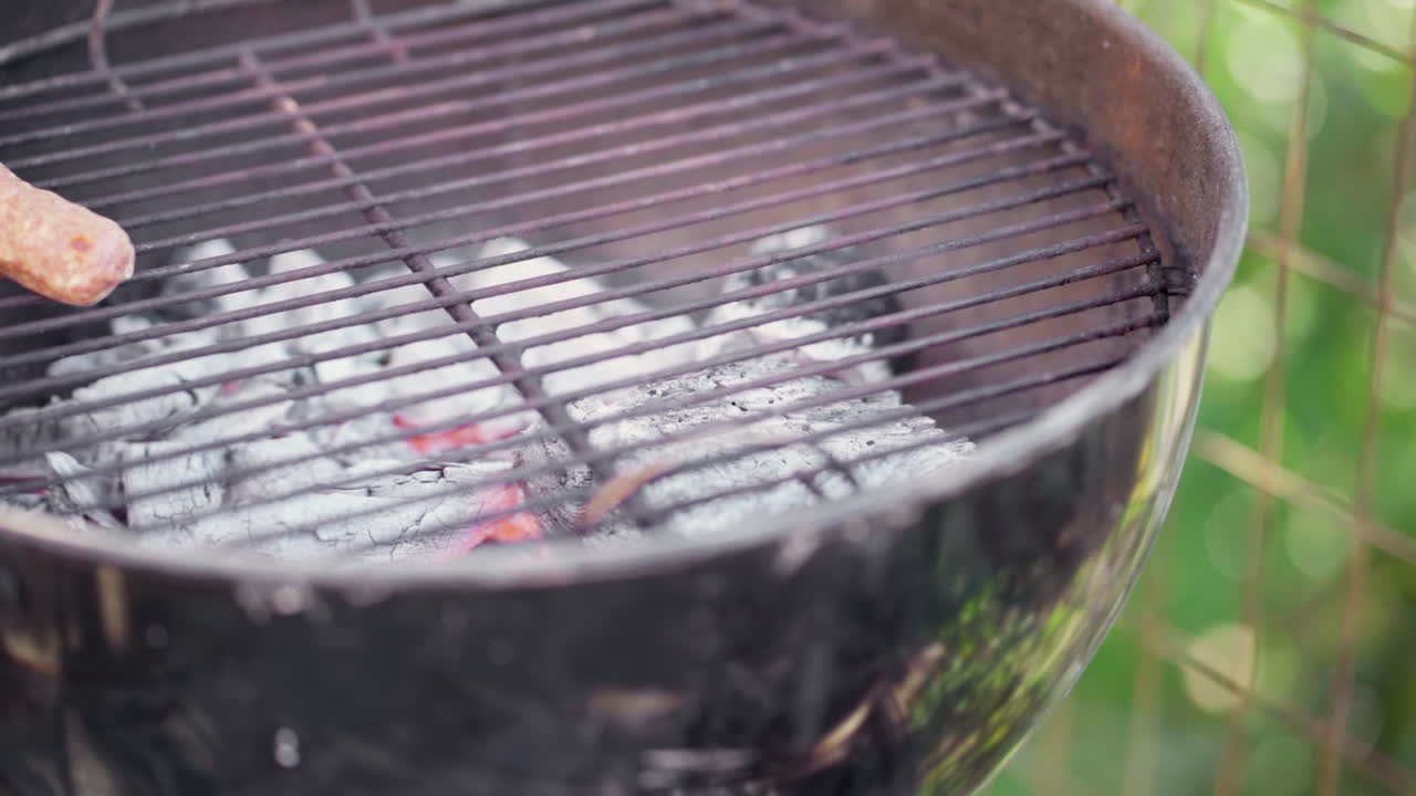 빈 스모키 바비큐 그릴에 놓인 신선한 소시지의 느린 동작