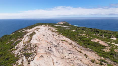 video de dron de 4k volando sobre dos personas que caminan por el sendero de la cabeza calva dentro del parque nacional de torndirrup en albany, australia occidental