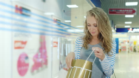 Young-Woman-Modeling-Appearance-With-Bags-For-Shopping-Is-The-Mall-He-Looks-At-Purchases-That-Are-In