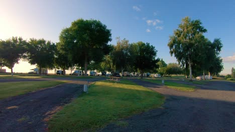 pan of an rv resort with asphalt roads and a few guests in the late afternoon