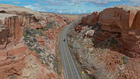 Carretera-Asfaltada-A-Través-De-Acantilados-De-Roca-Roja-Del-Parque-Nacional-Arches-En-Utah,-Estados-Unidos