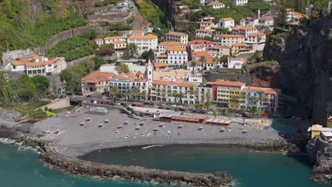 madeira, portugal small touristic resort town with private beach with black sand from drone