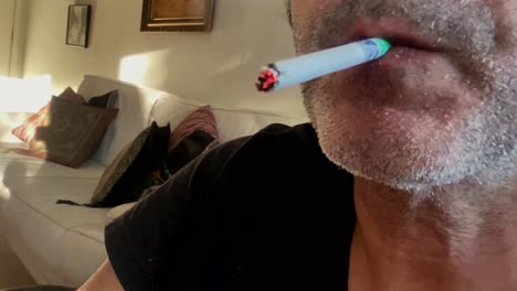 man lighting and smoking a cigarette