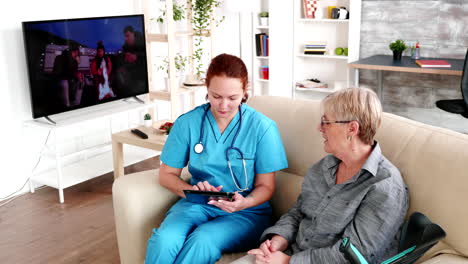 Female-nurse-holding-tablet-PC-in-retirement-home