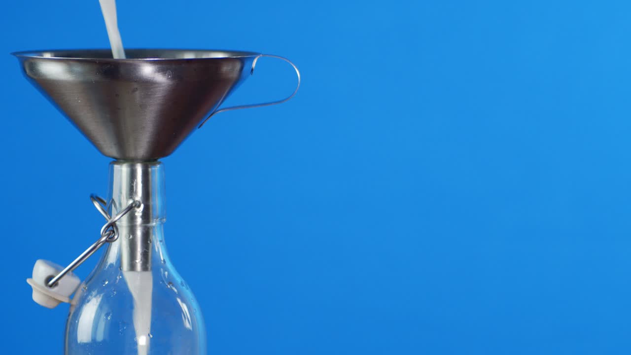Milk poured into the bottle through a funnel.