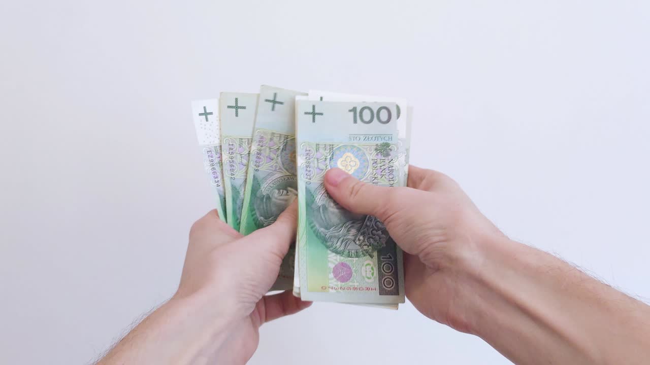 Mani che contano zloty polacchi. Uomo che conta banconote polacche da 100 zloty. Controllo della quantità di denaro contante.