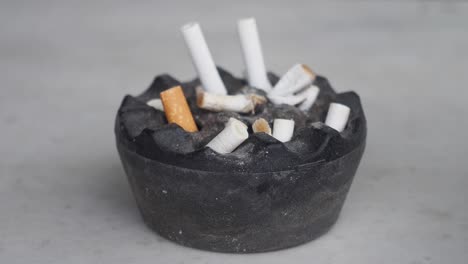 dirty ashtray with cigarette butts