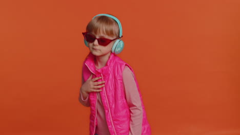 alegre chica atractiva escuchando música a través de auriculares y bailando discoteca tonteando alrededor divirtiéndose