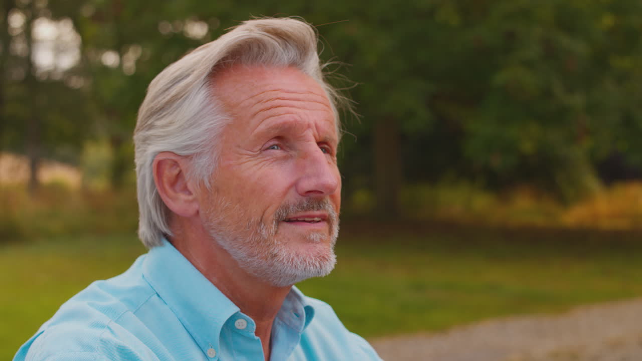 Portrait Of Smiling Casually Dressed Mature Or Senior Man Walking In Countryside