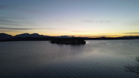 puesta de sol en el lago con montañas y bosques en baviera