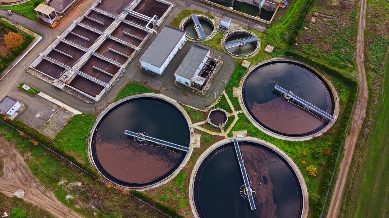 Wastewater treatment plant in action near a serene landscape during a sunny afternoon