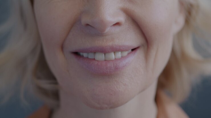Primo piano del volto sorridente di una donna anziana