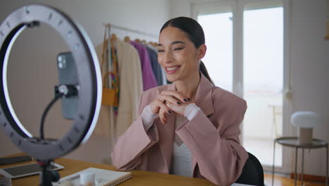 makeup artist turning smartphone filming blog closeup. winking woman greeting