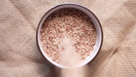 pouring brown rice into a bowl