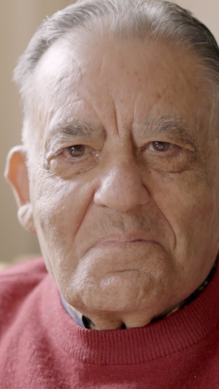 Anciano sonriendo a la cámara sentado en una residencia de ancianos