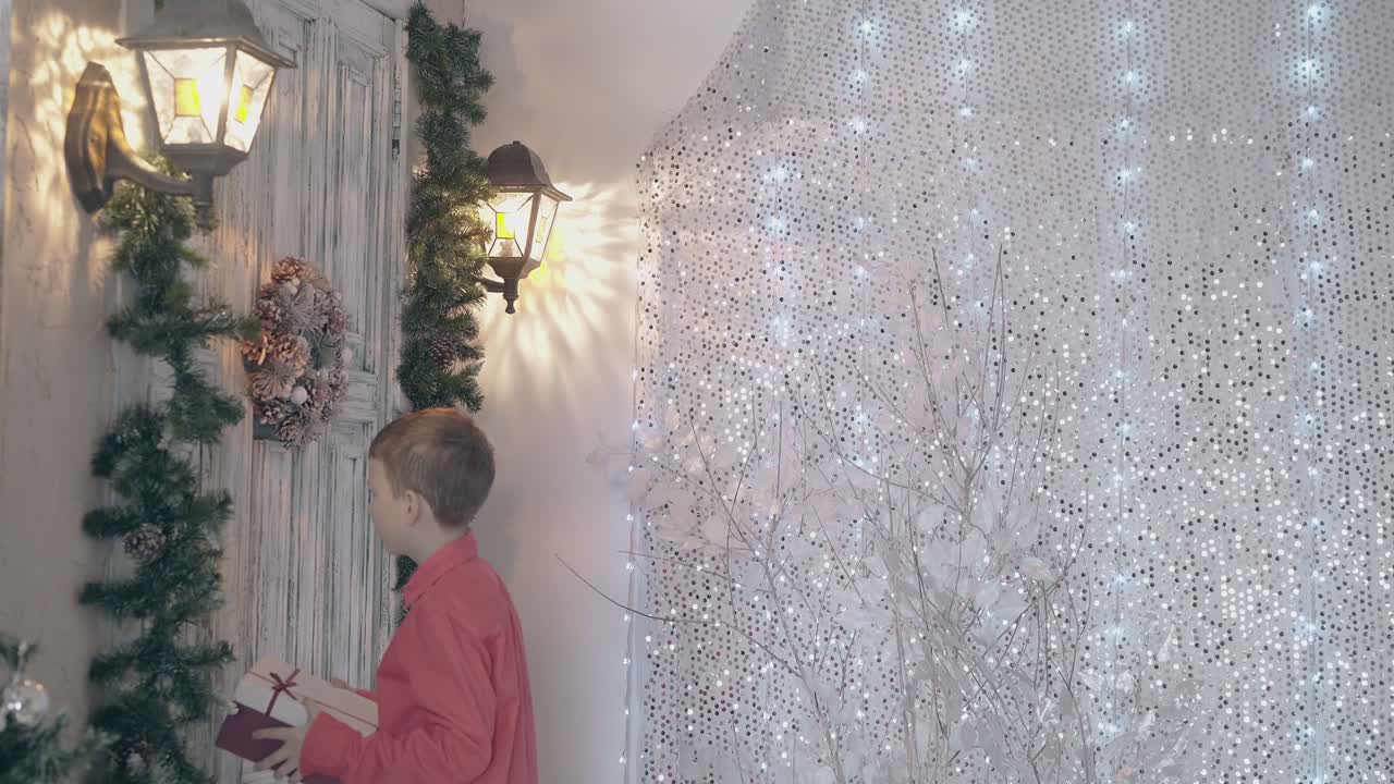 un niño con camisa roja y una caja de regalo en las manos llama a la puerta