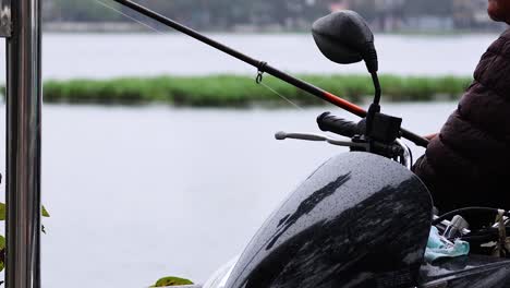 person fishing beside a lake in hanoi