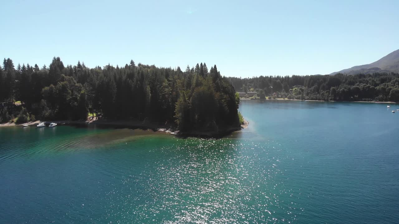 el sol brilla en la superficie del lago en vuelo aéreo en el punto del bosque