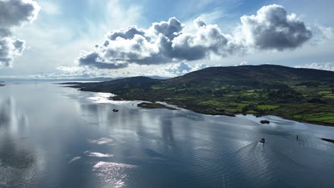 Drohne-Dramatischen-Frühen-Morgenhimmel-über-Bere-Island-In-West-Cork-Irland-Auf-Dem-Wild-Atlantic-Way-Mit-Ruhigem-Wasser-Und-Kleinem-Boot