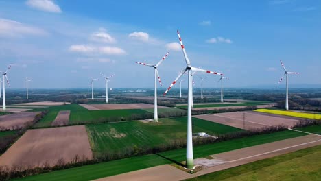 AERIAL---Wind-turbines-in-a-wind-energy-farm-in-Austria,-wide-spinning-shot