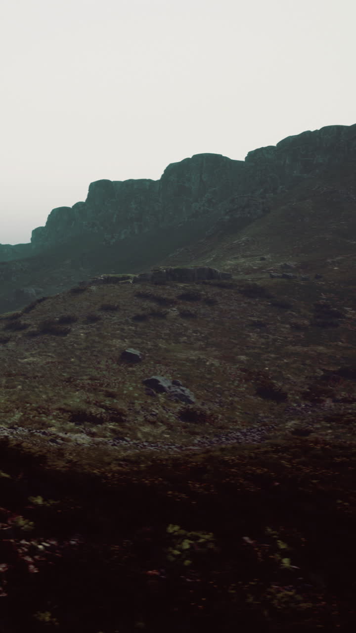 Mountain landscape with fog over rocky terrain in early morning light